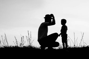 Çocuklu mutlu bir ebeveyn yaz siluetinde oynuyor.