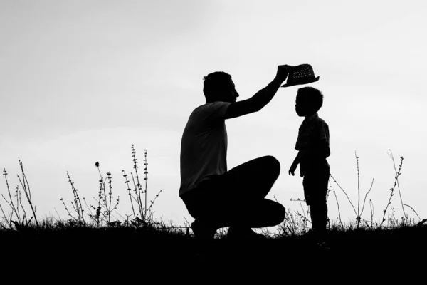 Genitore felice con bambini che giocano sulla silhouette estiva della natura — Foto Stock