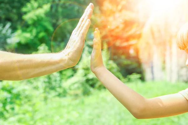 Hermosas manos de un niño y un padre en un parque en la naturaleza —  Fotos de Stock