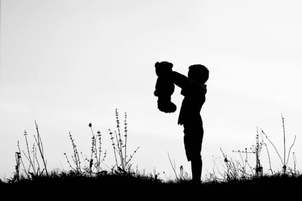 Šťastné děti hrají na přírodu letní silueta — Stock fotografie