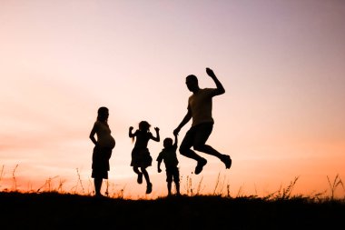 Mutlu aile doğada oynuyor yaz siluetinde