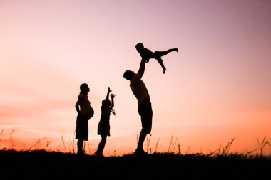 Mutlu aile doğada oynuyor yaz siluetinde