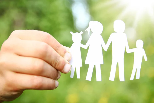 In the hands of the family on a background paper — Stock Photo, Image