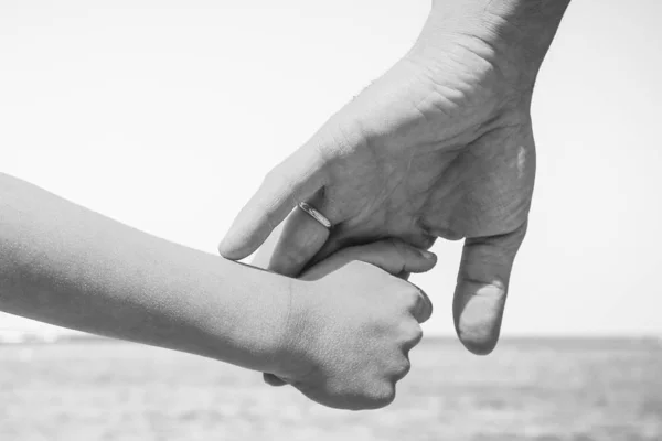 Stylové ruce rodiče a dítěte na pozadí moře — Stock fotografie