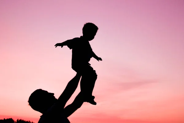 Genitore felice con bambini che giocano sulla silhouette estiva della natura — Foto Stock