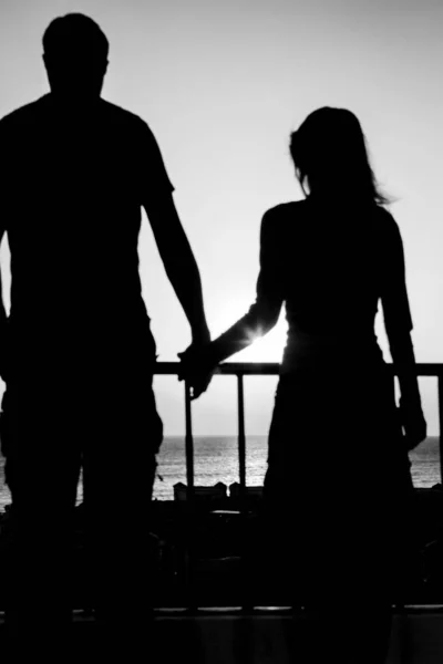 Beautiful couple silhouette on nature near the sea on a rift bac