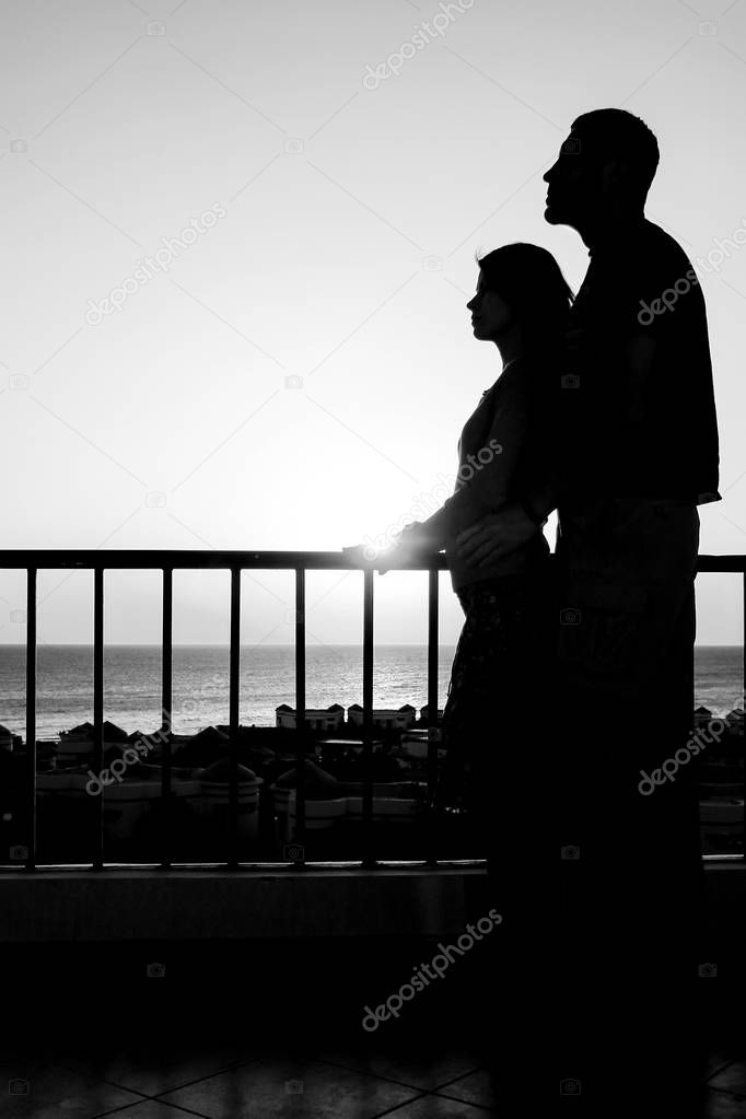 Beautiful couple silhouette on nature near the sea on a rift bac