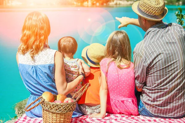 Familia feliz junto al mar en la naturaleza picnic — Foto de Stock