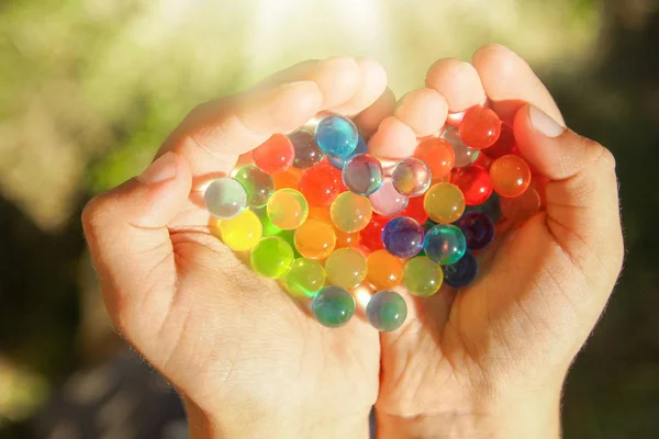 Bonito fondo de bolas de diferentes colores en las manos — Foto de Stock