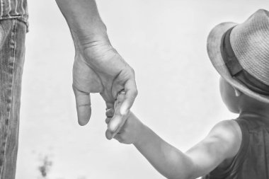 deniz tarafından bir parkta doğada bir ebeveyn ve çocuk elleri