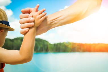 deniz tarafından bir parkta doğada bir ebeveyn ve çocuk elleri