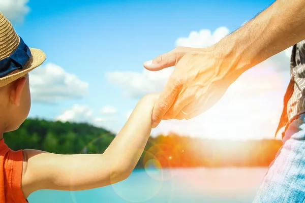 Τα χέρια ενός γονέα και παιδιού στη φύση σε ένα πάρκο δίπλα στη θάλασσα — Φωτογραφία Αρχείου