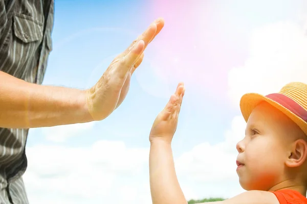 Manos de un padre y un niño en la naturaleza en un parque junto al mar —  Fotos de Stock