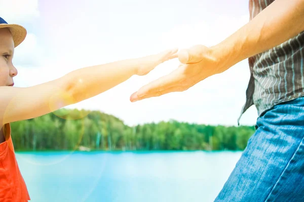 Hände eines Elternteils und eines Kindes in der Natur in einem Park am Meer — Stockfoto