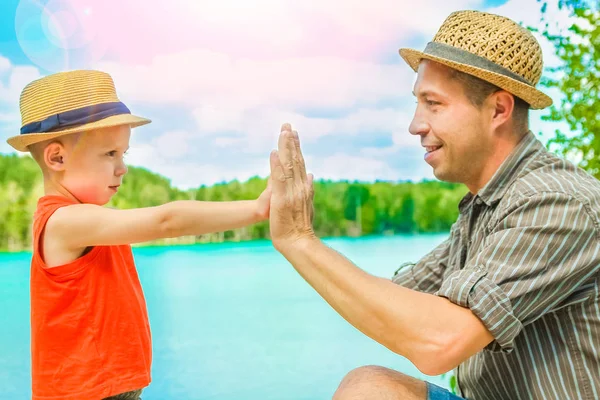 Mooie handen van een kind en een ouder in een park in de natuur — Stockfoto