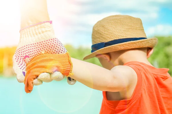 Hände eines Elternteils und eines Kindes in der Natur in einem Park am Meer — Stockfoto