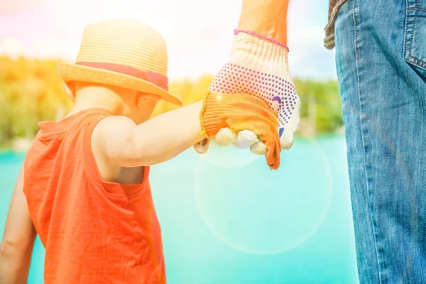 Hände eines Elternteils und eines Kindes in der Natur in einem Park am Meer — Stockfoto
