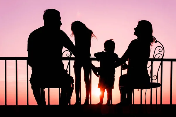 Happy family at the dawn of the sea silhouette background — Stock Photo, Image
