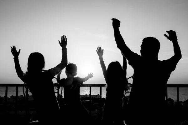 Bonne famille à l'aube de la silhouette de la mer fond — Photo