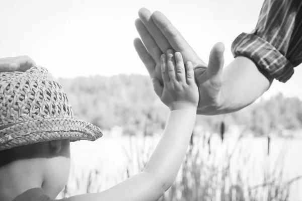 Mains d'un parent et d'un enfant dans la nature dans un parc au bord de la mer — Photo