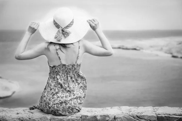 Stijlvol mooi meisje met hoed op de kust achtergrond — Stockfoto