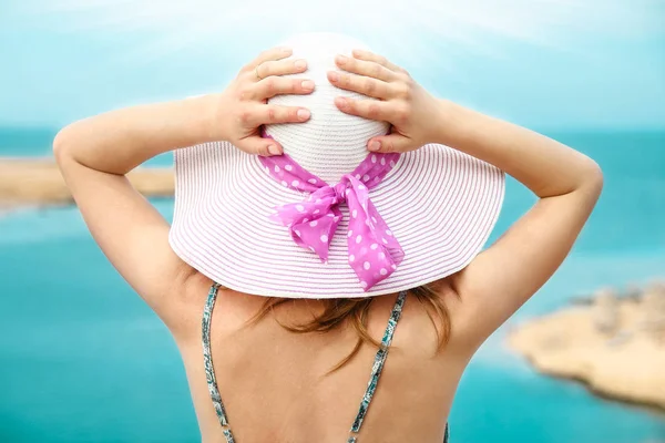 Stylish beautiful girl in hat on the seashore background — Stock Photo, Image