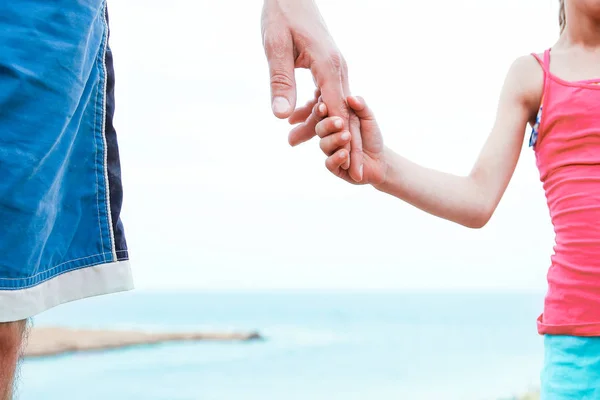 Vackra händer förälder och barn på havet bakgrund — Stockfoto