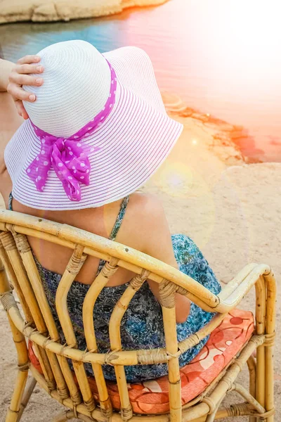 Stylish beautiful girl in hat on chair background — Stock Photo, Image