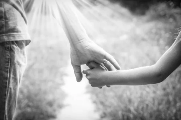 De ouder die de hand van het kind met een gelukkige achtergrond vasthoudt — Stockfoto