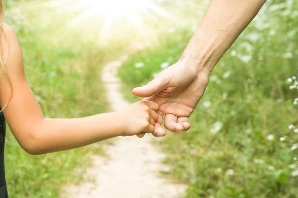 Föräldern som håller barnets hand med en lycklig bakgrund — Stockfoto