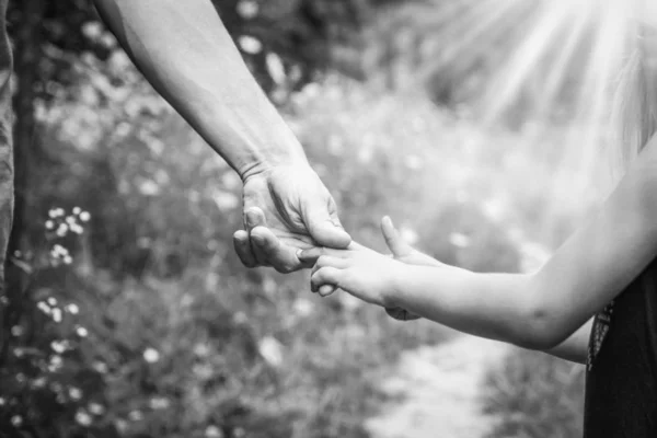 Föräldern som håller barnets hand med en lycklig bakgrund — Stockfoto
