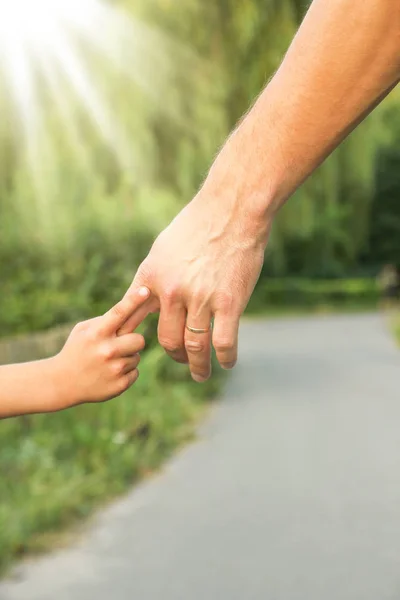 El padre sosteniendo la mano del niño con un fondo feliz —  Fotos de Stock