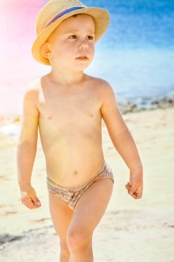 Mutlu çocuk deniz arka plan üzerinde oynarken