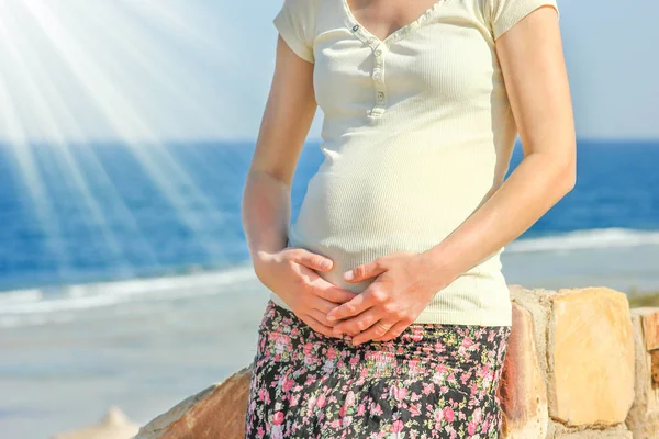 Беременная девушка на фоне моря — стоковое фото