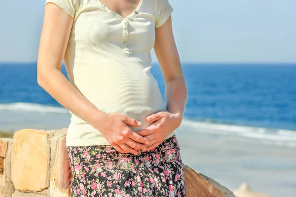 Beautiful pregnant girl at sea background Stock Image