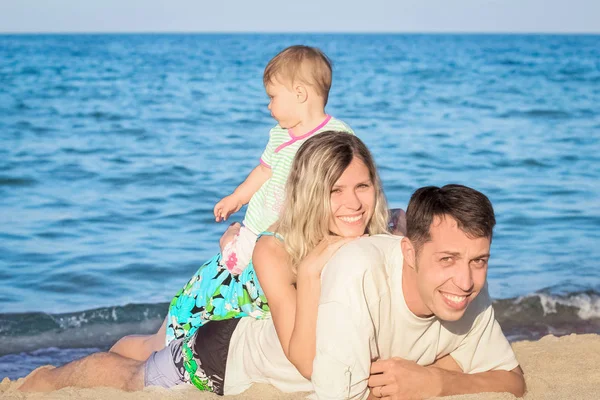 Famille heureuse jouant sur la mer dans la nature — Photo