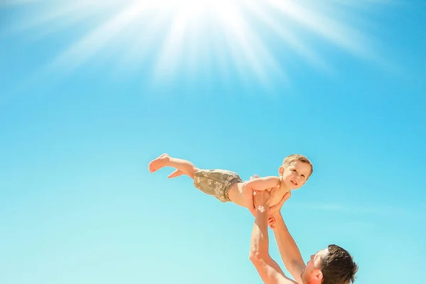 Счастливый родитель с ребенком играет на морском фоне — стоковое фото
