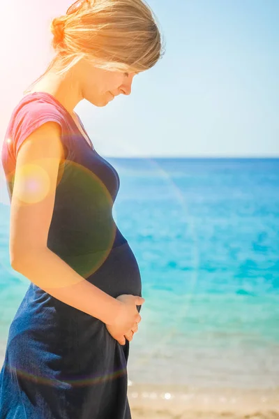 Krásná těhotná dívka na mořském pozadí — Stock fotografie