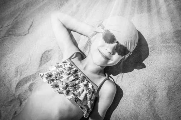 Niño feliz en gafas tomando el sol en el fondo de la costa —  Fotos de Stock