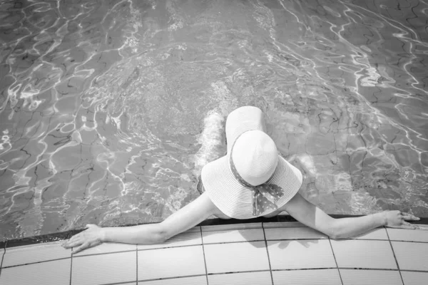 Счастливая девушка в шляпе у бассейна на море — стоковое фото