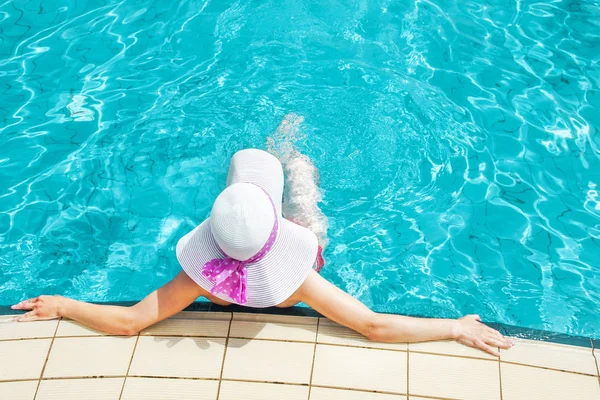 Gelukkig meisje in een hoed bij het zwembad op zee — Stockfoto