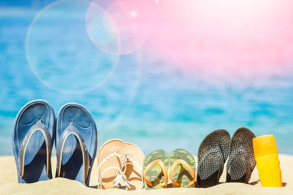 Elegantes zapatillas hermosas en la arena sobre el fondo del mar —  Fotos de Stock