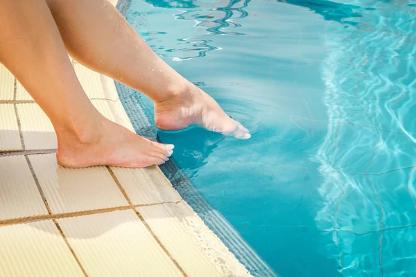 Beautiful legs of a girl near a swimming pool on the sea backgro — Stock Photo, Image