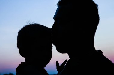 mutlu ana baba ile bebek siluet niteliğine bir parkta