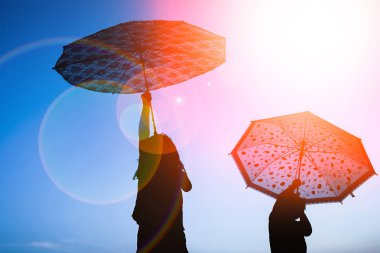 Park güneşinde doğa üzerinde bir şemsiye siluet ile Happy Kids