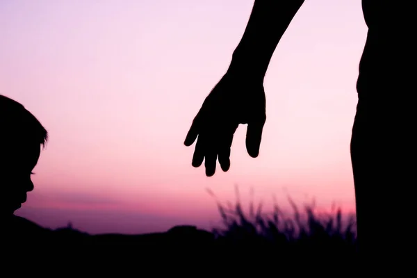 Pai pai feliz com silhueta de mão de bebê ao pôr do sol na natur — Fotografia de Stock