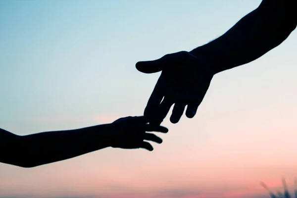 Happy parent father with baby hand silhouette at sunset in natur — Stock Photo, Image