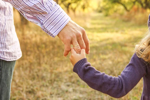 Mutlu bir geçmişi olan çocuğun elini tutan ebeveyn. — Stok fotoğraf