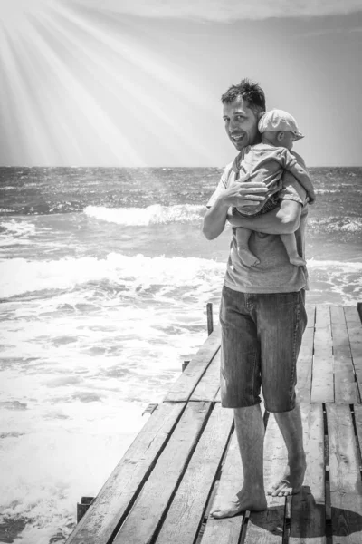 Parent heureux avec un enfant au bord de la mer en plein air — Photo