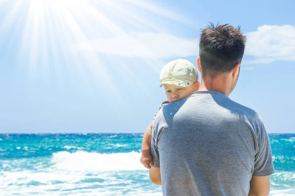 Padre feliz con un niño junto al mar al aire libre —  Fotos de Stock